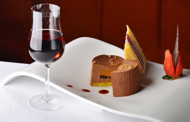 Glass of tawny port next to a plated dessert